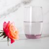 beautiful 13oz lavender Italian glass next to a flower.