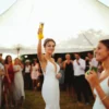 woman offering a toast while holding high her mini yard glass.